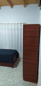 ein Schlafzimmer mit einem Bett und einem großen Holzschrank in der Unterkunft Posada Atardeceres in Puan
