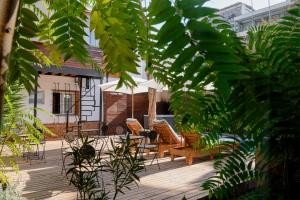 a patio with chairs and an umbrella and some plants at Verde Madera Hostel B&B in Santiago