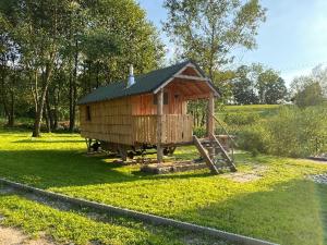 ein kleines Holzhaus mit einer Treppe im Gras in der Unterkunft Windmühlenhof in Dittmannsdorf