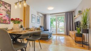 - un salon avec une table à manger et des chaises dans l'établissement New delux green garden apartment with hotube ****, à Split