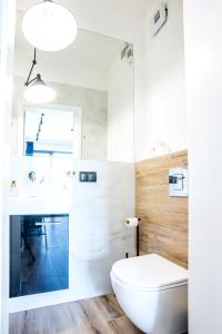 La salle de bains est pourvue de toilettes blanches et d'un lavabo. dans l'établissement Apartamenty Olimpijska z widokiem na jezioro, à Olsztyn