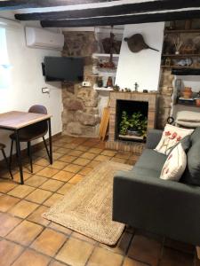 uma sala de estar com um sofá e uma lareira em El Refugi em Vilafamés