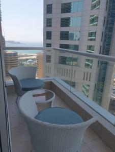 a balcony with chairs and a view of a building at Nasma Luxury Stays - Botanica Tower in Dubai