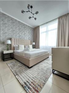 a bedroom with a large bed and a large window at Nasma Luxury Stays - Botanica Tower in Dubai