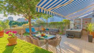 une terrasse avec une table, des chaises et un parasol dans l'établissement New delux green garden apartment with hotube ****, à Split