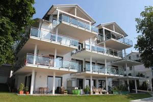 a large white building with balconies and tables at Rügen Star Appartements De Luxe in Sassnitz