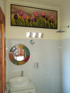 a bathroom with a painting of pink tulips on the wall at Pondok widji in Sukawati