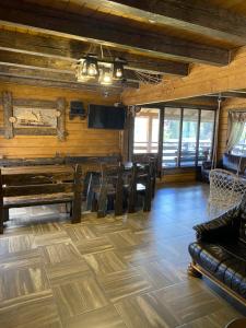 salon z drewnianymi ścianami, stołem i krzesłami w obiekcie Eco House w mieście Bukowel