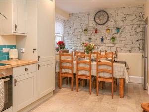 una cucina e una sala da pranzo con tavolo e sedie di Happy Feet Cottage, Sleeps 6 a Bradwell