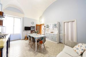 a kitchen and living room with a table and a couch at La casa di Tina a 20 metri dal mare in Santo Stefano al Mare +10 photos
