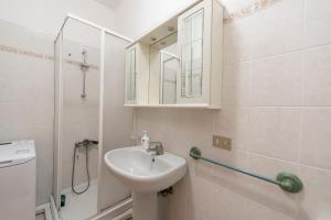 y baño blanco con lavabo y ducha. en La casa di Tina a 20 metri dal mare en Santo Stefano al Mare