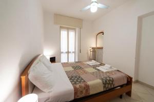 a bedroom with a bed and a mirror and a window at La casa di Tina a 20 metri dal mare in Santo Stefano al Mare