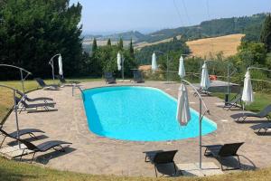 - une piscine avec des chaises longues et des parasols dans l'établissement Villa Fienile Design, à SantʼAppiano