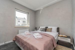 a bedroom with a bed with two towels on it at Flatbook Apartamenty - Sztutowo Baltic Twins in Sztutowo
