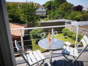 een balkon met een tafel en 2 glazen wijn bij Un instant avec vous in Saint-Martin-Boulogne