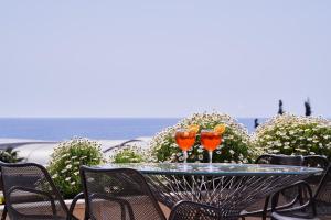 two wine glasses sitting on a table on a patio at Atlantica Bay - Adults Only in Limassol