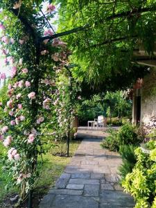a walkway covered in roses in a garden at Tenuta La Quassa in Ispra
