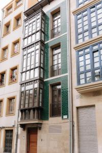 un edificio con pintura verde al costado. en San Bernardo, 19, en Avilés