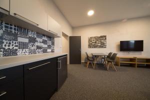 a kitchen and dining room with a table and a tv at Replay apartmány in Frenštát pod Radhoštěm