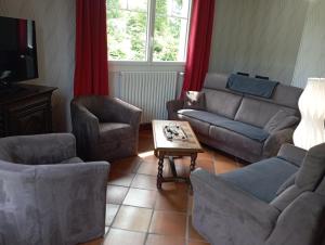 La Maison au Cœur de l Auvergne في Lanobre: غرفة معيشة مع أريكة وكراسي وطاولة