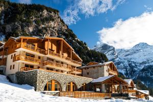 un hotel en las montañas con nieve en el suelo en Lagrange Vacances Les Hauts de la Vanoise en Pralognan-la-Vanoise