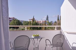 a small table and chairs on a balcony with a view at Atlantica Bay - Adults Only in Limassol