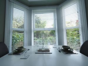 a white table with two bowls and glasses and windows at Grosvenor Suite in Royal Tunbridge Wells