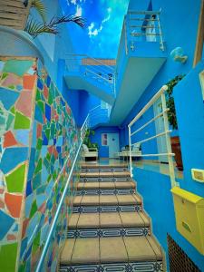 a swimming pool with stairs and a blue building at Apartamentos Mar Azul Arinaga in Arinaga