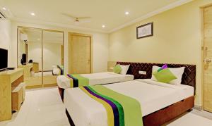 a hotel room with two beds and a television at Treebo Trend ASL Prime in Kolkata