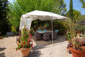 a white tent with chairs and flowers in a garden at Mas a 4 Mains in Cesseras