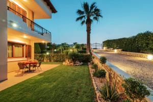 a backyard with a table and a palm tree at Filerimos HillSide Villa in Pastida