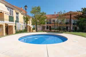a swimming pool in the middle of a driveway at VILLA by the beach. Pool, Priv Parking and Golf in Torre de Benagalbón