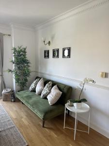a living room with a green couch and a table at Large 2 Bedroom Marina View Apartment in Hemel Hempstead