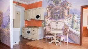 a kitchen with a table and a painting on the wall at Hotel Madrid in Odesa
