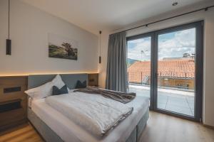 sypialnia z łóżkiem i dużym oknem w obiekcie Thalhof Apartments w mieście Brixen im Thale