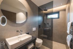 a bathroom with a sink and a toilet and a mirror at Thalhof Apartments in Brixen im Thale