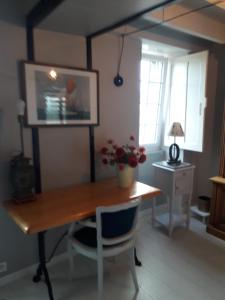 una sala da pranzo con tavolo in legno e scrivania di reve capel a Urville-Nacqueville