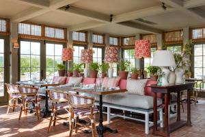 a restaurant with tables and chairs and windows at The Cavendish Hotel at Chatsworth in Baslow