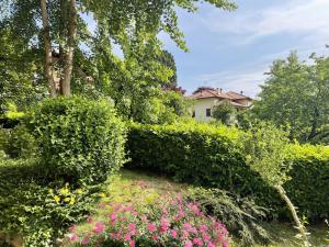 Lucio Fontana's experience في Comabbio: حديقة فيها شجيرات وزهور امام المنزل