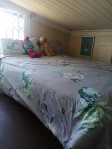 zwei ausgestopfte Tiere auf einem Bett in der Unterkunft Mariena Glen apartment 34- 3 bedroom beach house in Southbroom