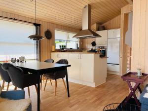 Tranekær的住宿－Sommerhus Dänemark，厨房以及带桌椅的用餐室。