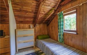 a bedroom in a log cabin with a bed and a window at Nice Home In Wilimy With Kitchen in Wilimy