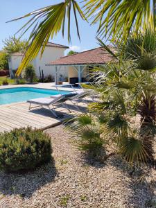 a villa with a swimming pool and a house at Le Clos Fleuri proche de Bordeaux in Saint-Sulpice-et-Cameyrac