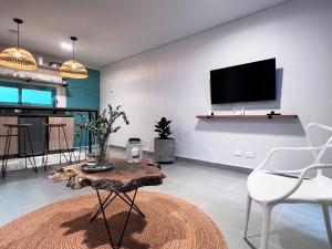 a living room with a tv and a table and chairs at Parallelo Loft Salento P2 in Salento