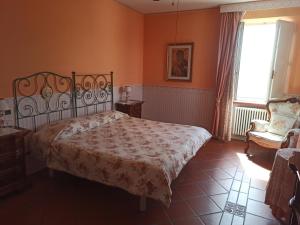 a bedroom with a bed and a chair and a window at Da Cristina in Monsampolo del Tronto