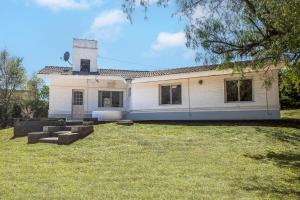 uma casa branca com uma torre no topo de um quintal em Paz y Confort em La Falda