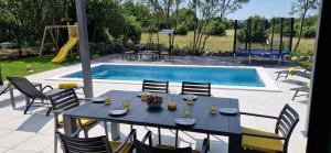 a table with wine glasses on it next to a pool at Villa Lotta in Labin