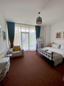 a bedroom with a bed and a couch and a chair at Mood Hotel Kazbegi in Kazbegi