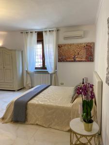 een slaapkamer met een bed en een tafel met bloemen erop bij My Home in Rome in Rome