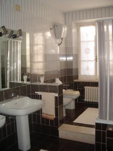 a bathroom with two sinks and a toilet and a window at Da Cristina in Monsampolo del Tronto